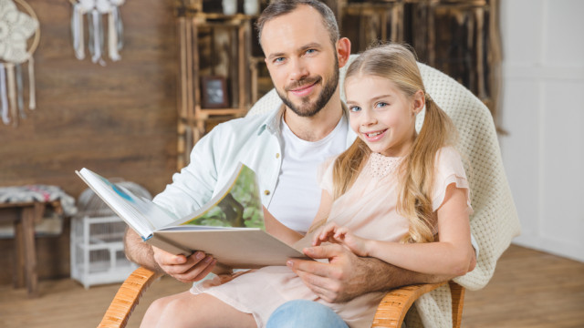 папа читає книгу доньці