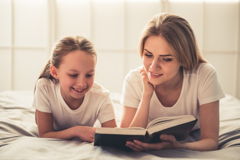 Девочка читает с мамой
