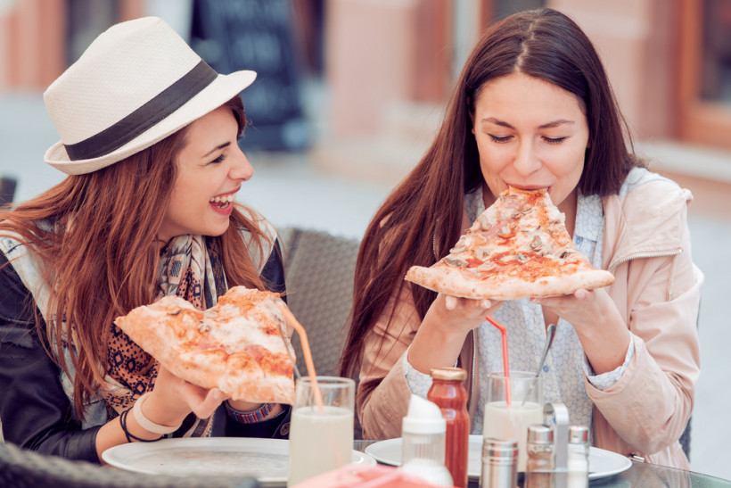 Девушки едят пиццу