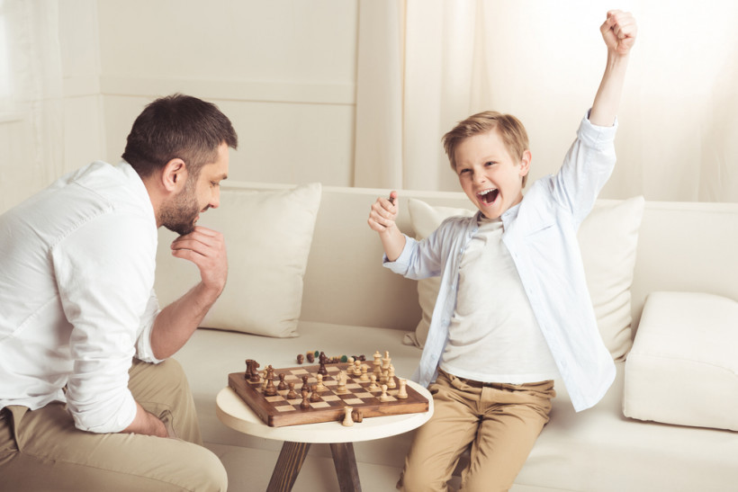 папа с сыном играет в шахматы