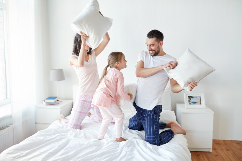 счастливая семья дерется подушками