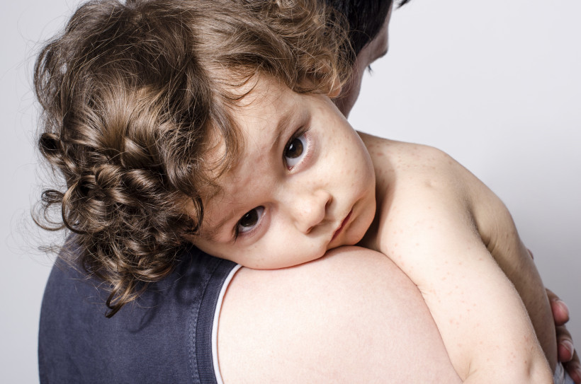 Вакцинация - ребенок на руках у родителя