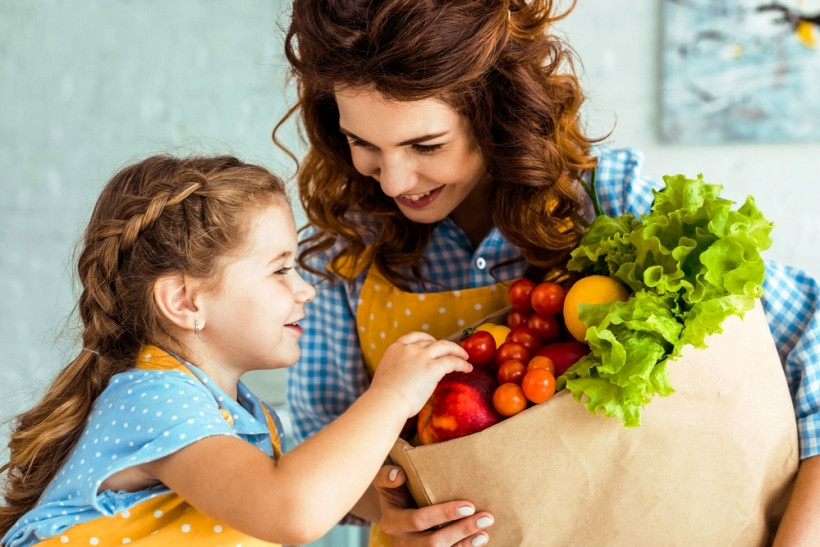 мама и дочь на кухне с пакетом овощей