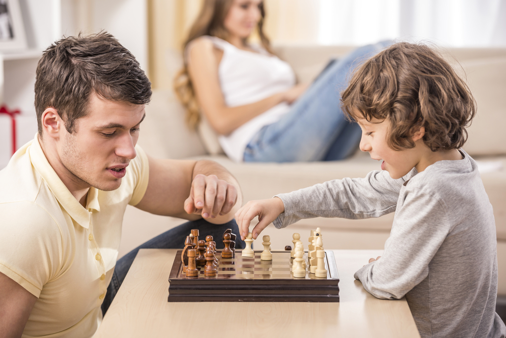 папа с сыном играют в шахматы