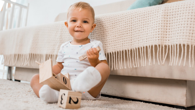 малыш сидит возле кровати