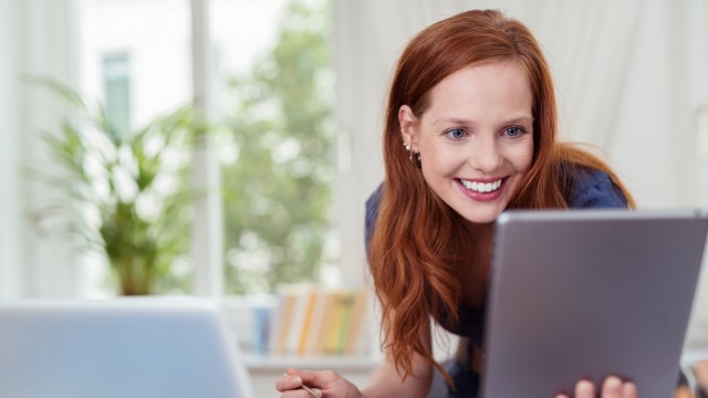 Жінка їсть на роботі, ноутбук і планшет, офісний працівник