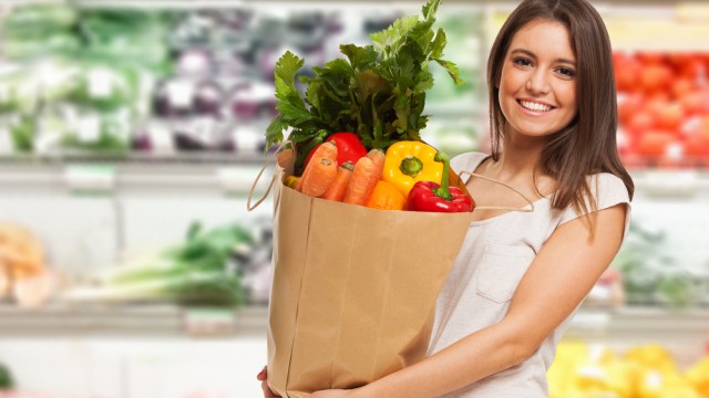 девушка держит пакет с продуктами