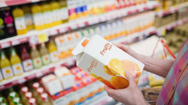 Покупатель выбирает сок в магазине