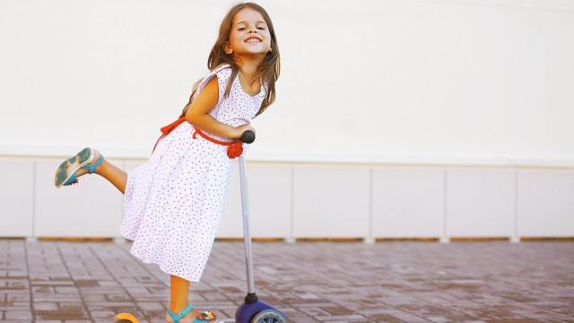 Девочка катается на самокате 