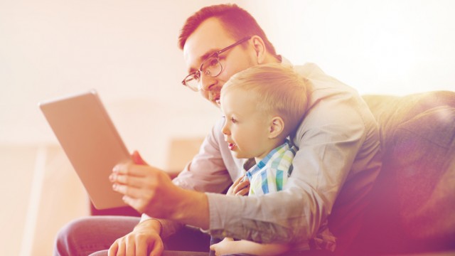 Тато і дитина дивляться в планшет