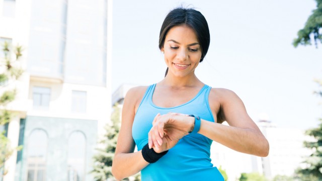 Дівчина дивиться на фітнес-браслет