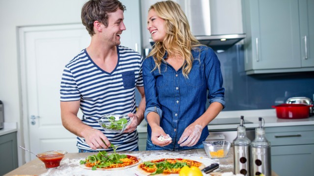 Пара готує піцу на кухні