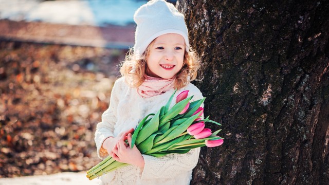 Дівчинка тримає тюльпани