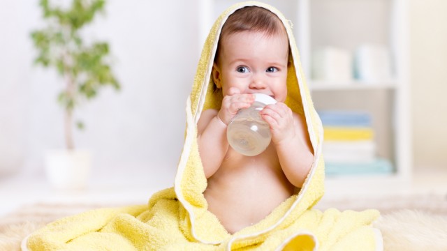 Малыш держит бутылочку с водой