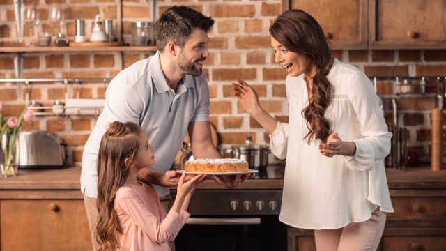 дочка готовит торт с родителями