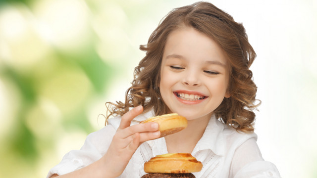 Девочка ест пончики