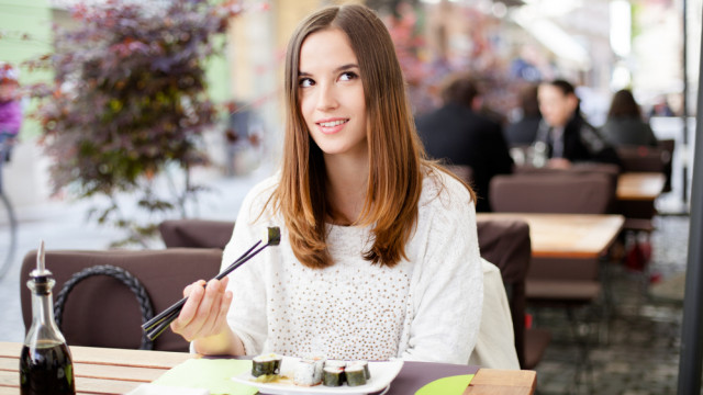 Дівчина їсть суші