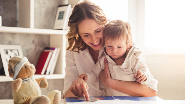 Мама читает книгу с сыном за столом