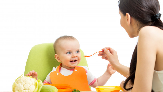 мама кормит малыша вкусным пюре