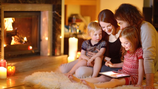 Сім'я з планшетом біля каміну