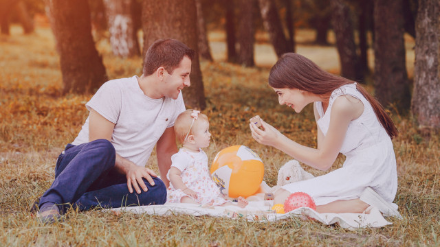 мама і тато грають з донькою в парку