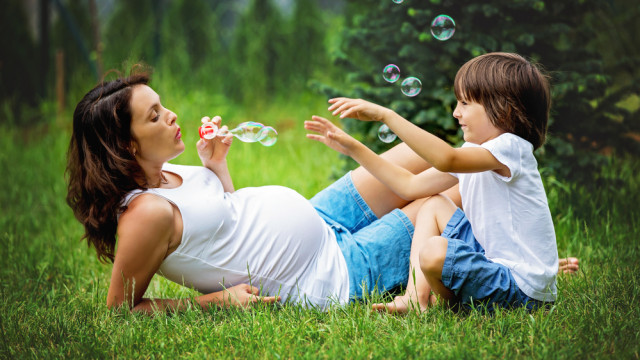 Беременная женщина играет с сыном