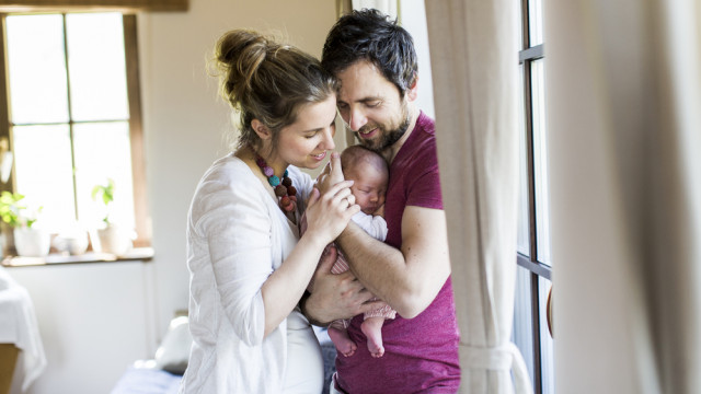 Молодые родители с младенцем дома