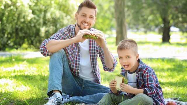 Папа и сын кушают сендвичи