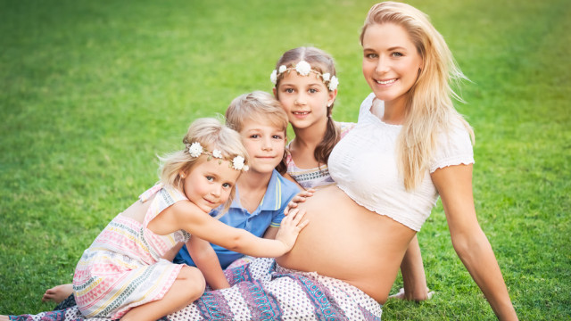 Беременная мама с детьми на лужайке