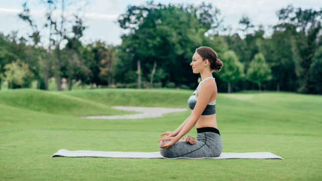 Дівчина медитує на галявині