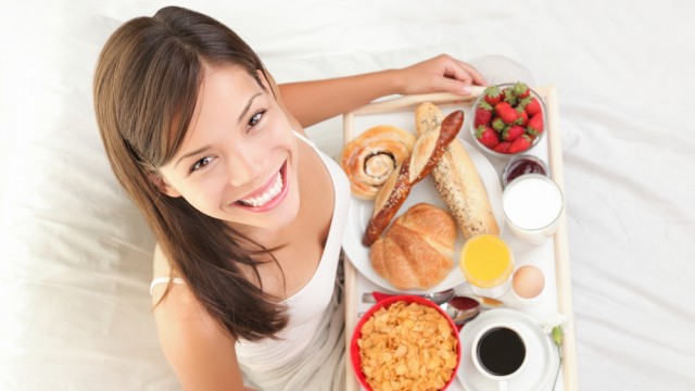 Дівчина снідає в ліжку