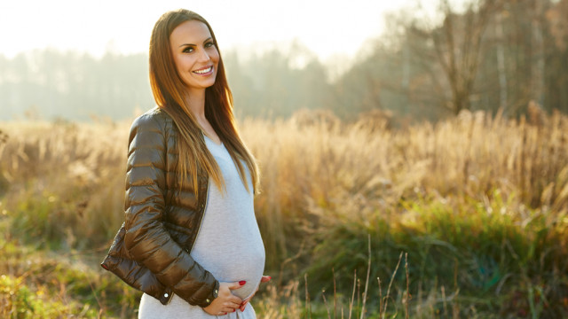 Красивая беременная на прогулке в парке