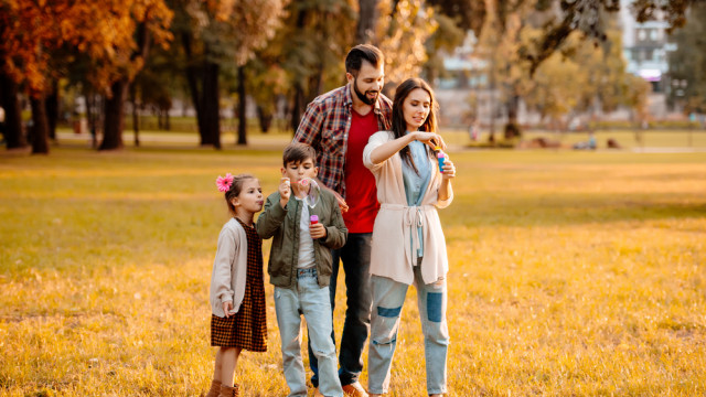 Родители с двумя детьми в осеннем парке