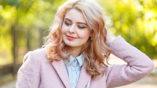 Блондинка в рожевому пальто