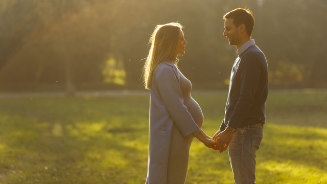 Беременная держится за руки с мужем