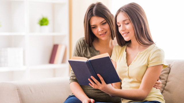 Девочка с мамой читает книгу дома