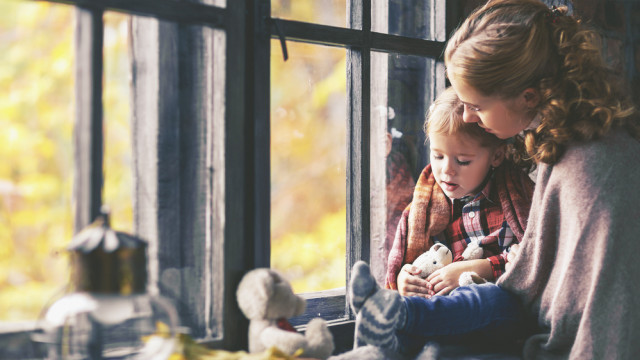 Мама с ребенком возле окна