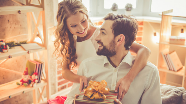 Женщина дарит подарок мужу