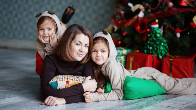 Мама с дочками позируют возле ёлки