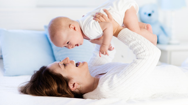 Мама держит ребенка на руках в постели