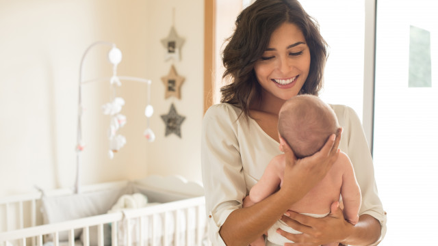 молодая мама держит на руках младенца