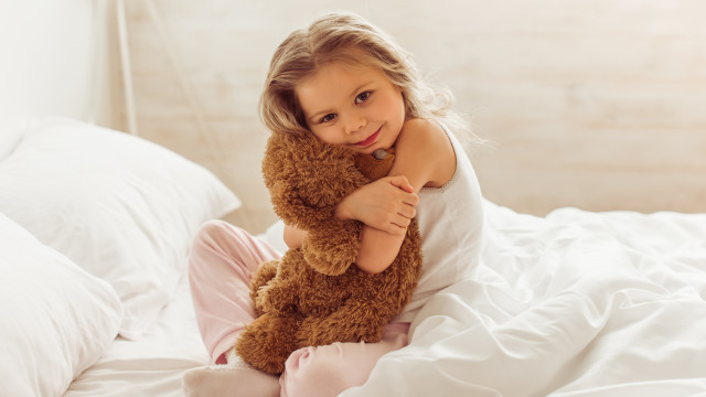 малышка обнимает плюшевого мишку