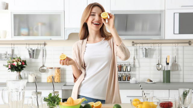 красива жінка робить сік на кухні