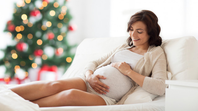 Красива вагітна лежить у вітальні