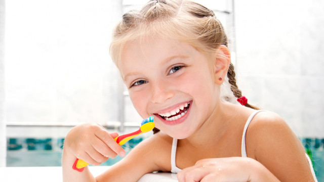 девочка улыбается и чистит зубы