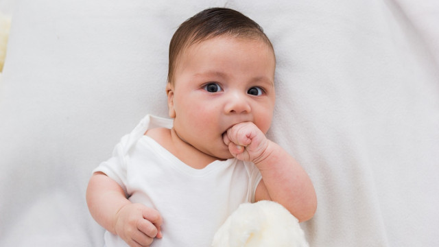 младенец сосет палец