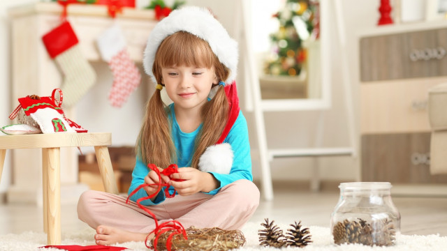 девочка делает поделку дома