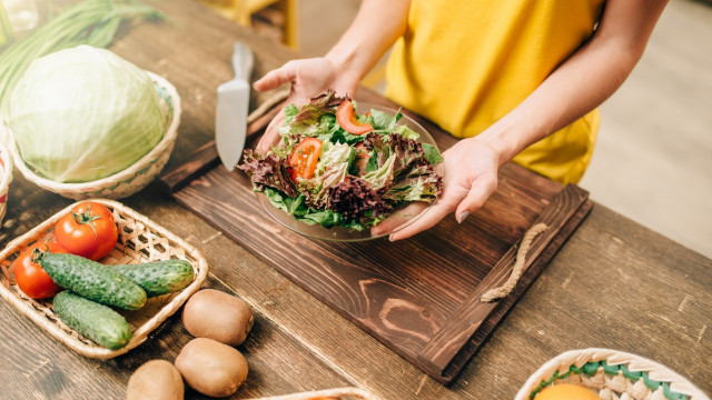 жінка тримає овочевий салат