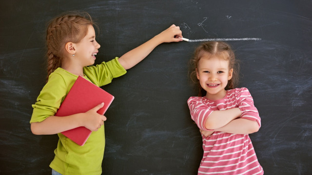 девочка мерят рост сестре