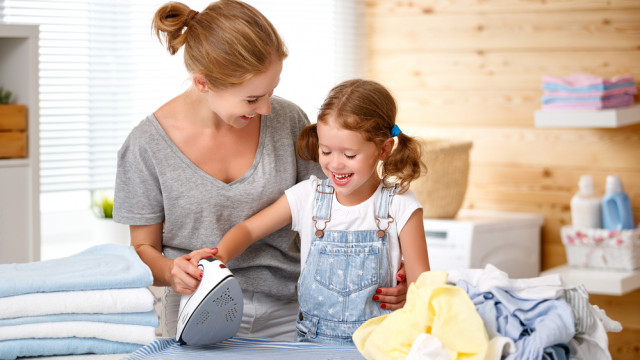 мама учит дочку пользоваться утюгом